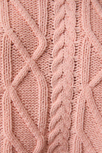 Close-up of pink knitted fabric with cable pattern
