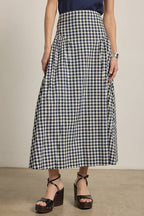 Person wearing a navy and white checkered skirt with a neutral background