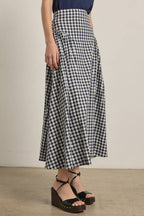 Person wearing a navy and white checkered skirt with a plain background