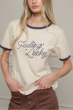 Woman wearing a white t-shirt with 'Feeling Lucky' text against a plain background