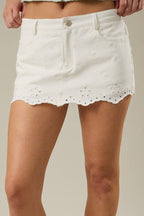White denim skirt with lace trim worn by a person on a neutral background