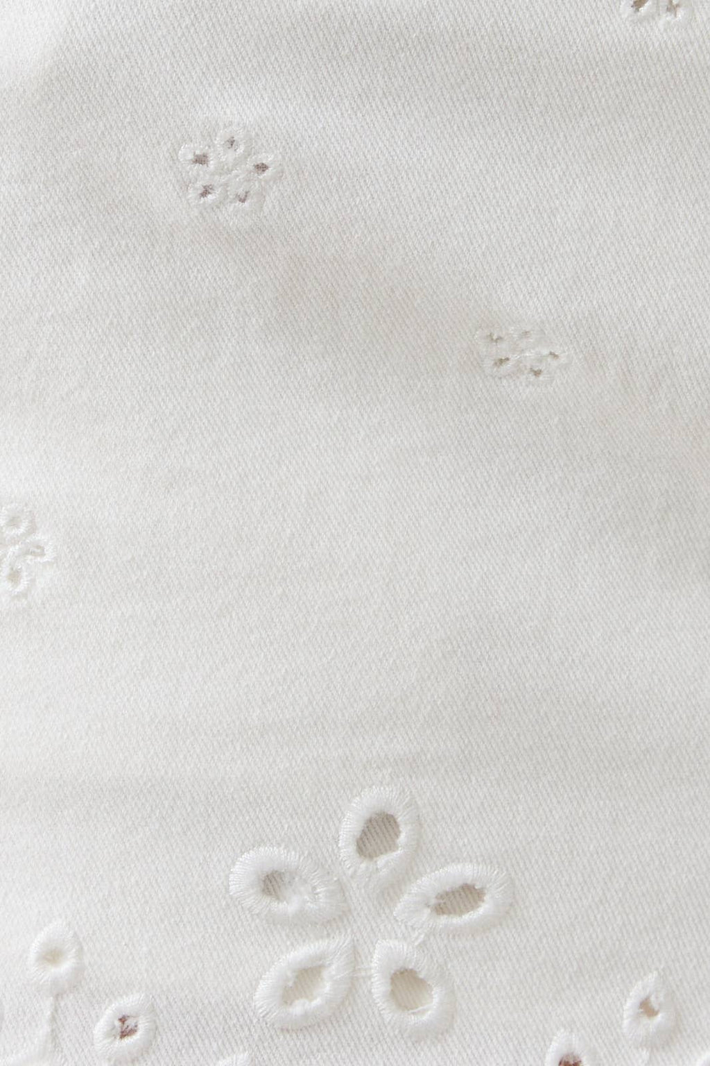Close-up of a white fabric with floral embroidery pattern