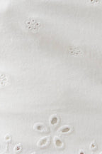 Close-up of a white fabric with floral embroidery pattern