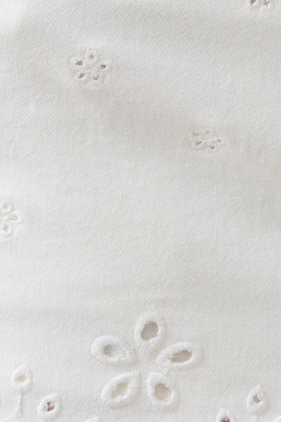 Close-up of a white fabric with floral embroidery pattern
