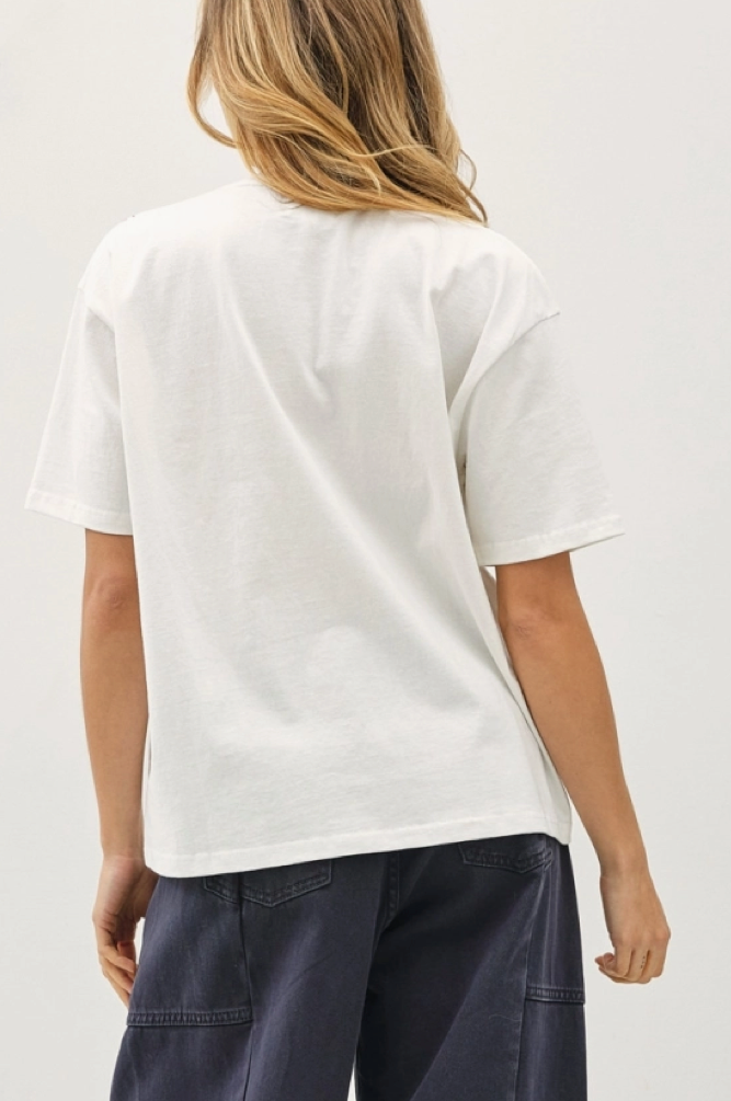 A model shown from the back wearing a white short-sleeve t-shirt and dark navy wide-leg pants,