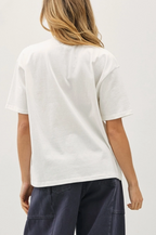 A model shown from the back wearing a white short-sleeve t-shirt and dark navy wide-leg pants,