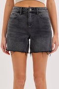 Person wearing black denim shorts on a white background