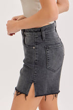 Woman wearing a strapless top and denim skirt on a white background