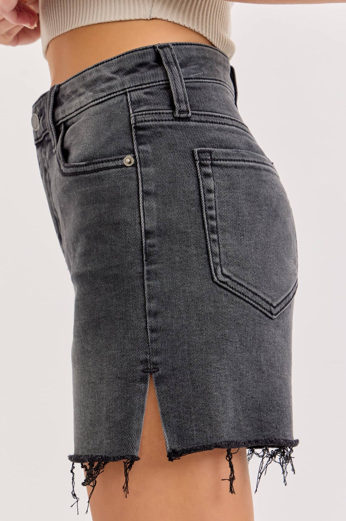 Black denim skirt worn by a person on a light gray background