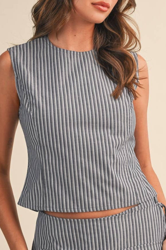 Woman wearing a sleeveless striped top on a beige background
