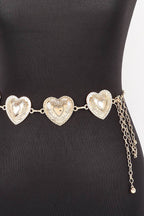 A silver-toned metal chain belt with three large textured heart-shaped links and dangling chain tails, displayed on a black mannequin torso against a white background.