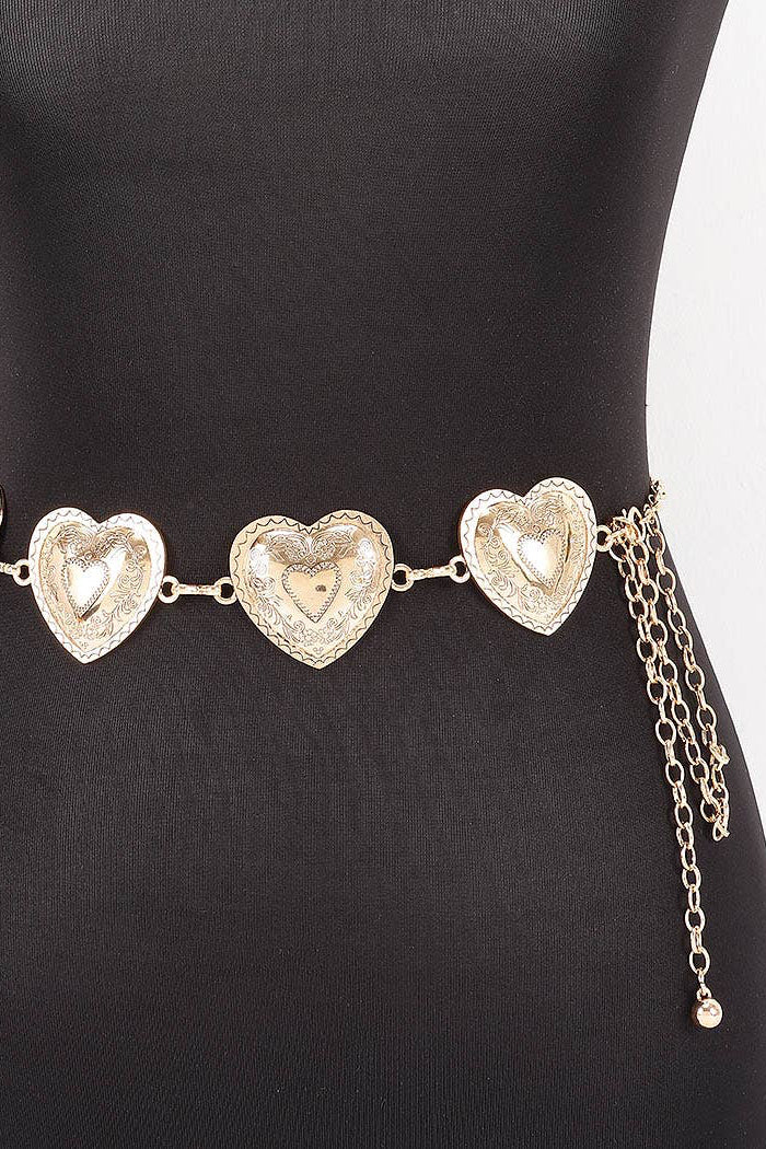 A silver-toned metal chain belt with three large textured heart-shaped links and dangling chain tails, displayed on a black mannequin torso against a white background.