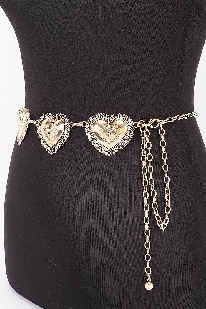 Gold heart-shaped belt with chain on a black mannequin against a white background