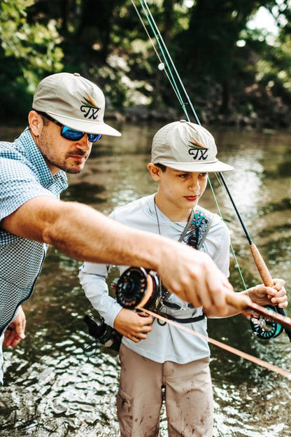 Man and young boy fishing together by a river