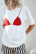 Person wearing a white t-shirt with a red bikini design and black and white striped shorts.