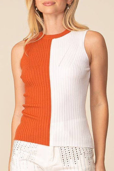 Woman wearing a sleeveless top with orange and white color block design on a beige background
