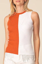 Woman wearing a sleeveless top with orange and white color block design on a beige background