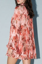 Woman wearing a floral dress against a plain background