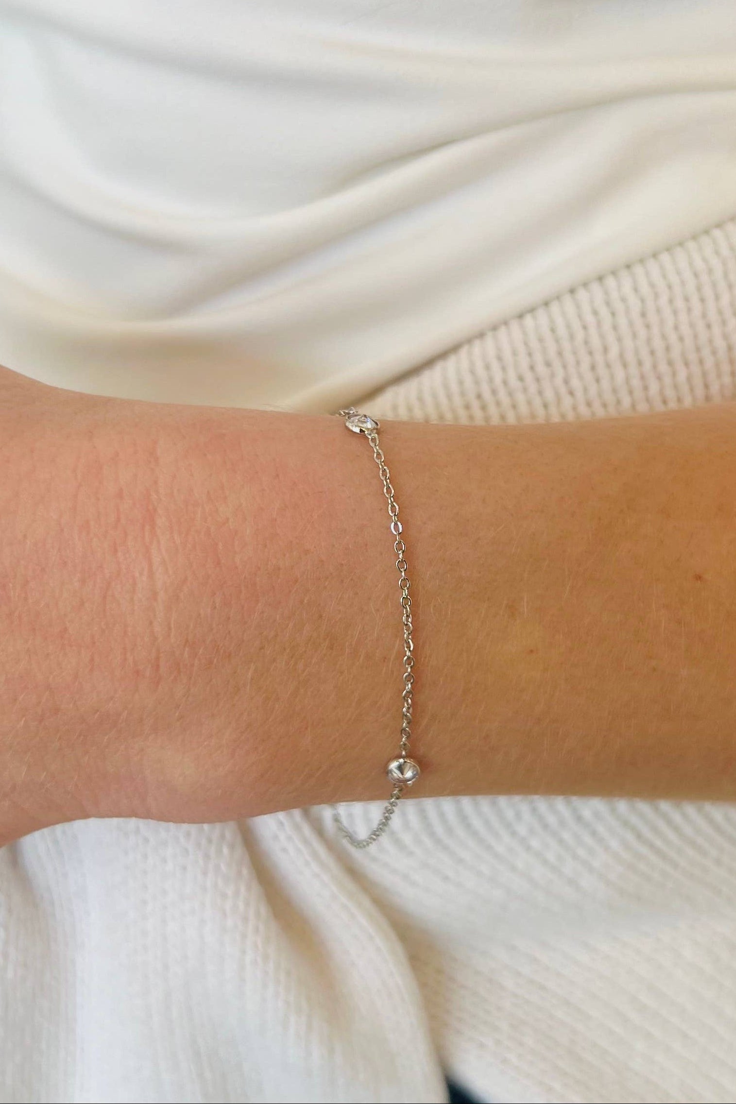 Silver bracelet on a person's wrist with a blurred background