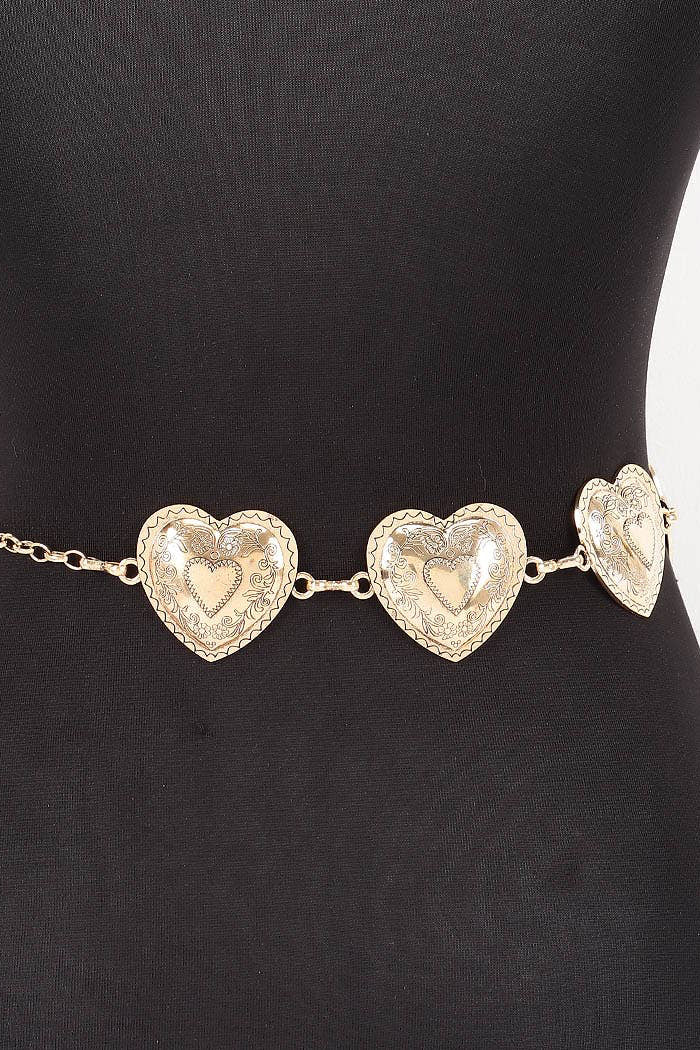 A gold heart chain belt with three textured heart charms displayed on a black mannequin torso.