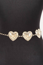 A gold heart chain belt with three textured heart charms displayed on a black mannequin torso.