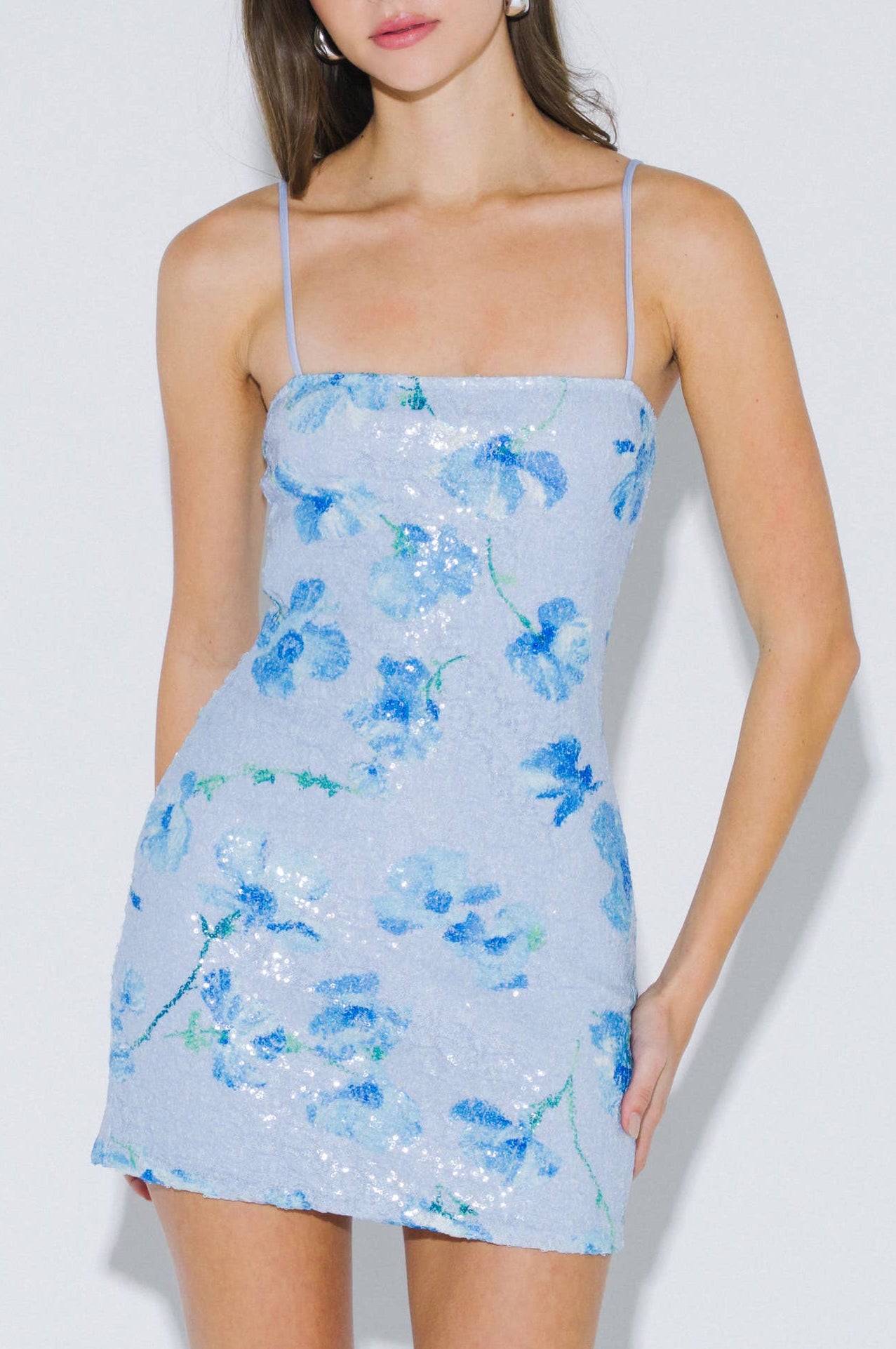 Woman wearing a blue floral dress against a white background