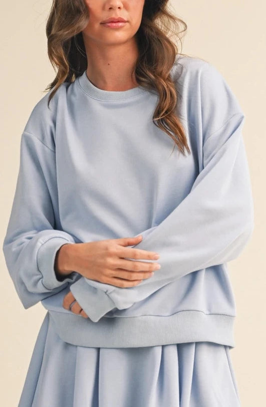 Woman wearing a light blue outfit on a beige background
