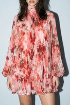 Woman wearing a floral dress against a plain background