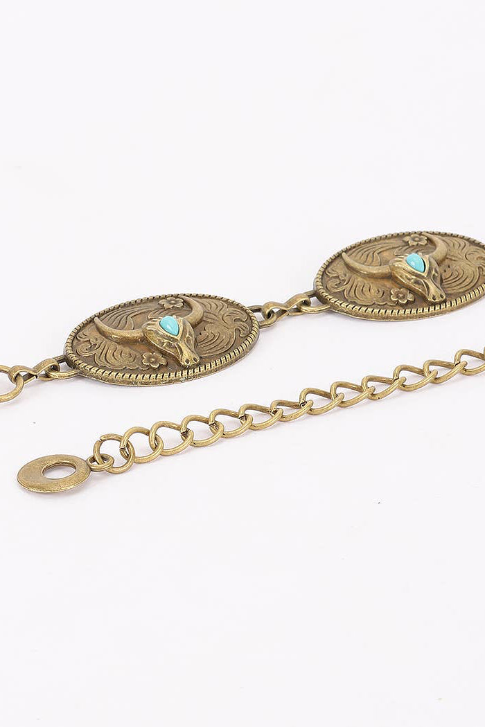 An antique bronze-toned metal chain bracelet featuring oval concho-style medallions with engraved western motifs and small turquoise accents, shown on a plain white background.