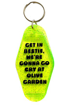 Keychain with text 'Get in bestie, we're gonna go cry at Olive Garden' on a yellow background