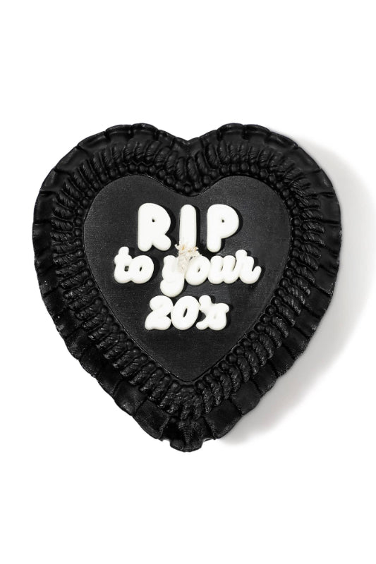 Black heart-shaped cake candle with 'RIP to your 20s' text on a white background