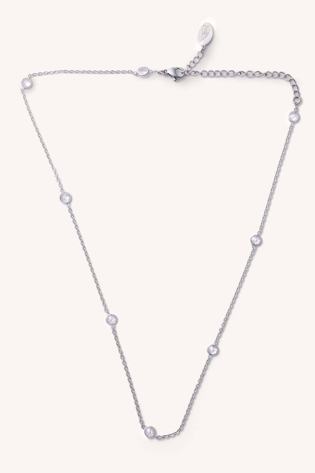 Silver necklace with small diamonds on a light purple background