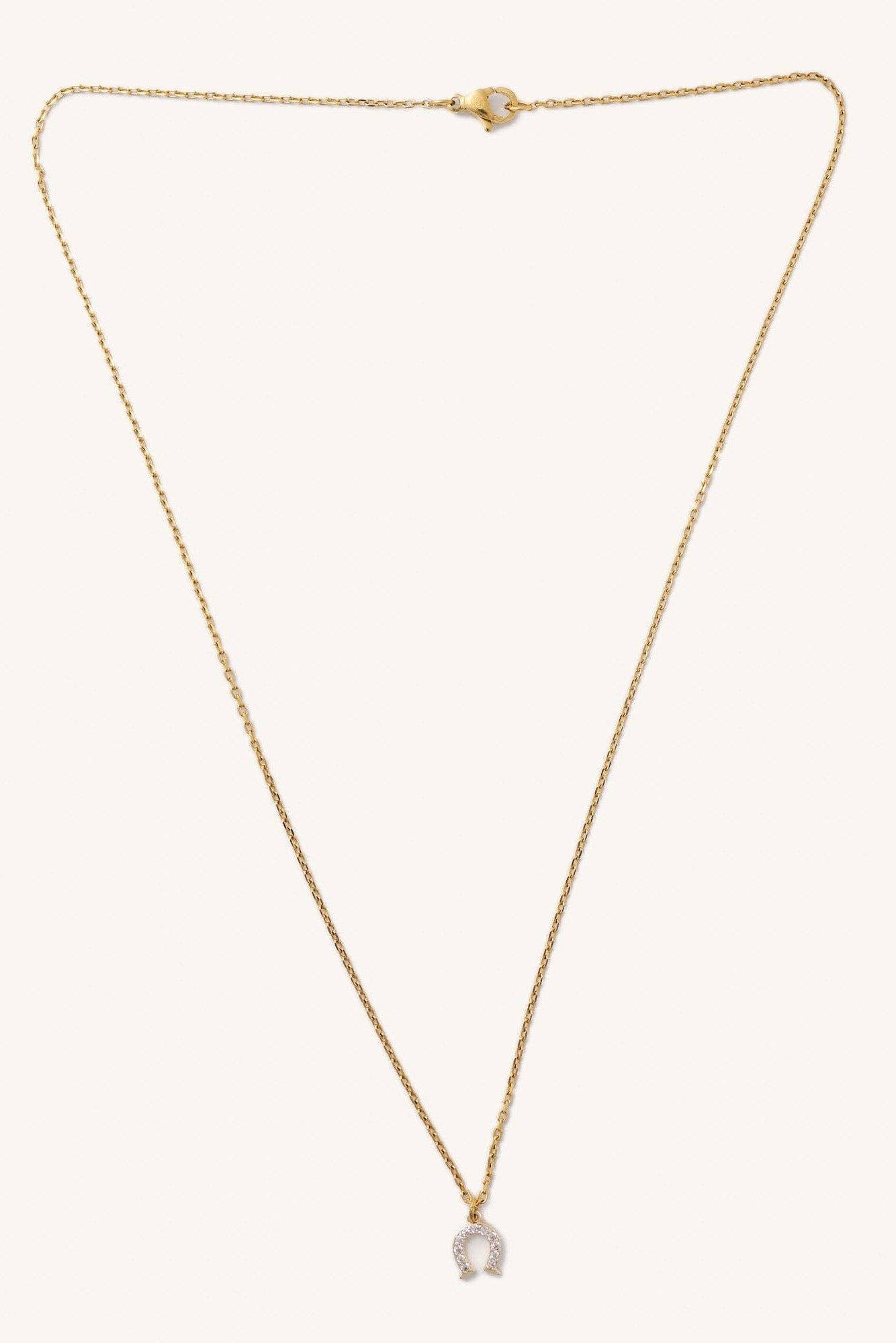Gold necklace with a small pendant on a white background