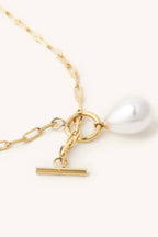 Gold necklace with a pearl pendant on a white background